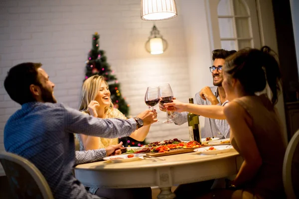 Jóvenes celebrando Año Nuevo y bebiendo vino tinto —  Fotos de Stock