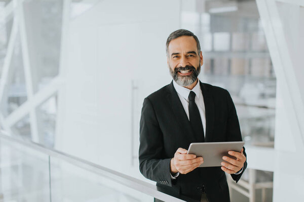 Средневековый бизнесмен с планшетом в офисе
