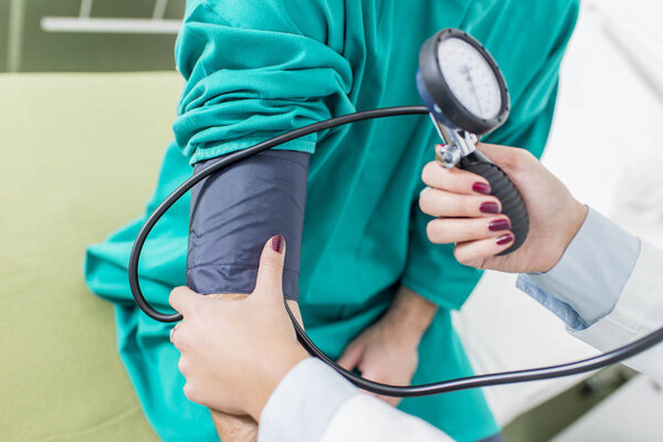 Female doctor checking blood pressure of a patient