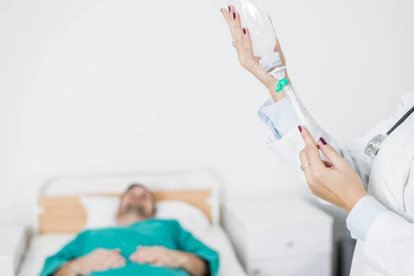 Kvinnliga läkare förbereder en injektion medan patienten är i sängen — Stockfoto