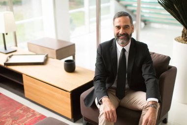 Yakışıklı işadamı lobide oturan