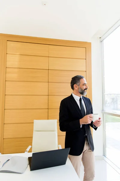 Uomo d'affari di mezza età con pausa caffè in ufficio moderno — Foto Stock