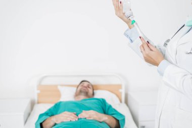 Hasta yatağında iken kadın doktor iğne hazırlar