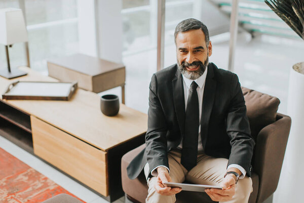 Уверенный старший бизнесмен с цифровым планшетом
