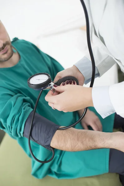 Médico femenino que revisa la presión arterial de un paciente — Foto de Stock