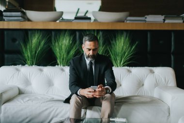 Orta yaşlı işadamı cep telefonu kullanma modern office