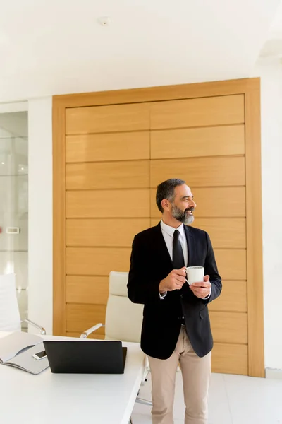 Uomo d'affari di mezza età con pausa caffè in ufficio moderno — Foto Stock