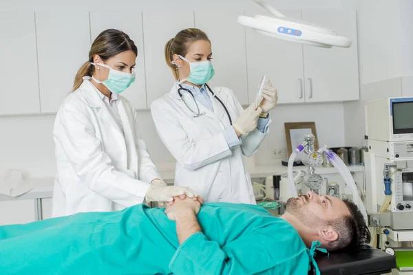 Médicas preparando paciente para intervenção — Fotografia de Stock