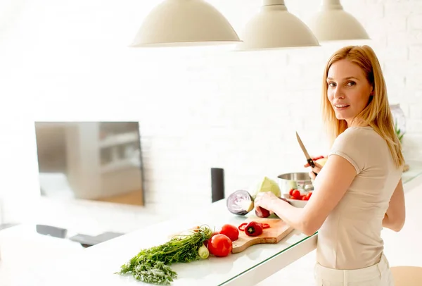 Ganska ung kvinna förbereder hälsosam måltid i köket — Stockfoto