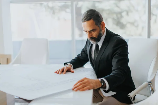 Beau milieu d'âge homme d'affaires regardant les plans — Photo