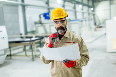 Fabrika planında bakarak yakışıklı olgun mühendisi