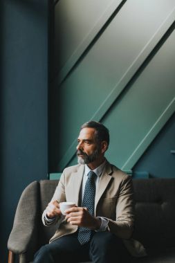 Yakışıklı adam kahve içiyor.