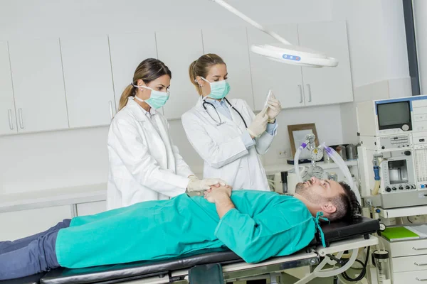 Female doctors preparing patient for intervention — Stock Photo, Image