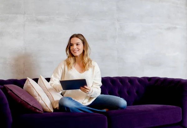 デジタル タブレットのソファの上を持つ若い女性 — ストック写真