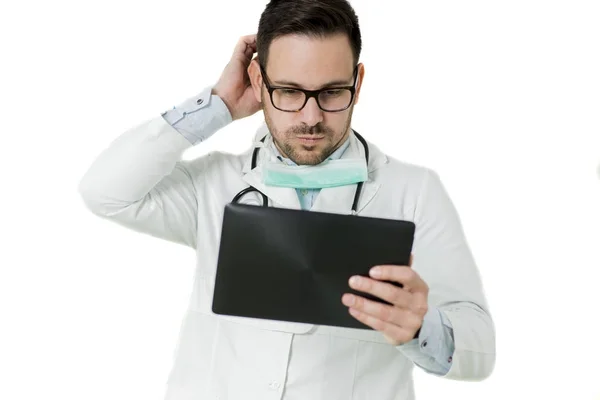 Молодой врач с цифровой табличкой на белой стене — стоковое фото
