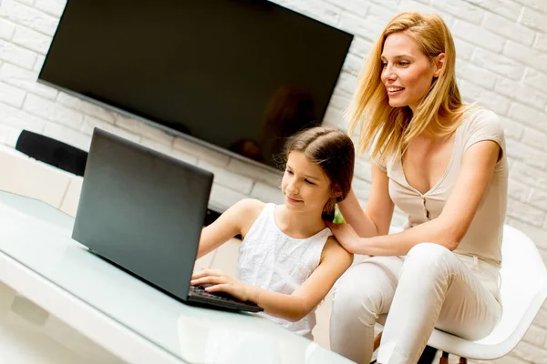 Mother and daughter using laptop at home — Stock Photo, Image