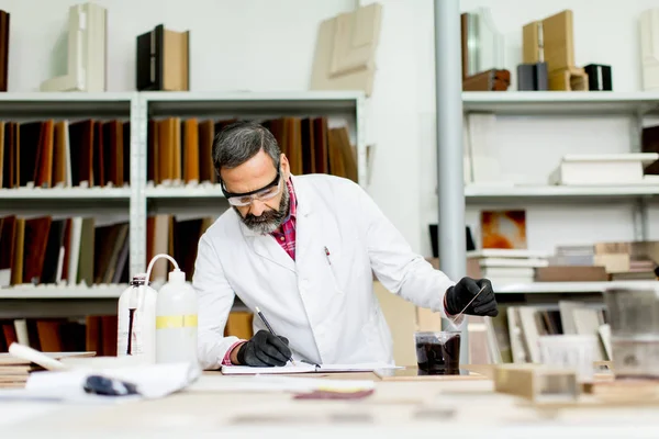 Ingeniero maduro guapo que trabaja en el laboratorio en los muebles — Foto de Stock