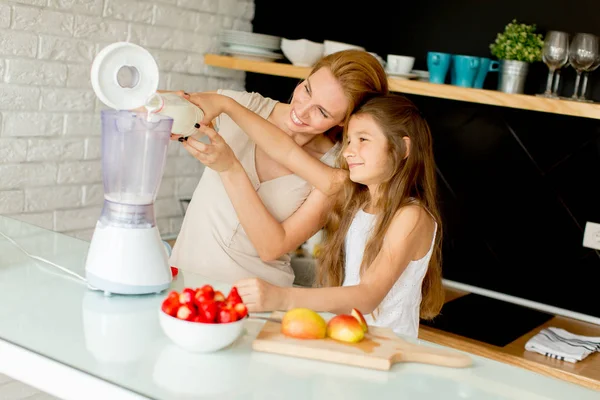 Mãe e filha preparando suco saudável — Fotografia de Stock