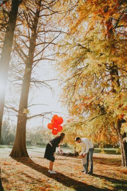 Mutlu anne bebek çocuk sonbahar Park kırmızı balonlar holding ile eğlenin