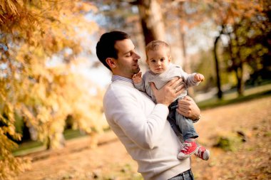 Genç Baba ve güneşli gün sonbahar parkta oynarken bebeğim