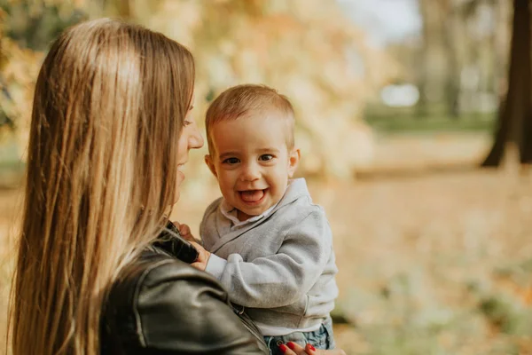 Joven madre y bebé en el parque de otoño — Foto de Stock