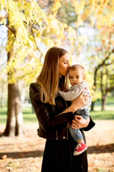 Joven madre y bebé en el parque de otoño — Foto de Stock