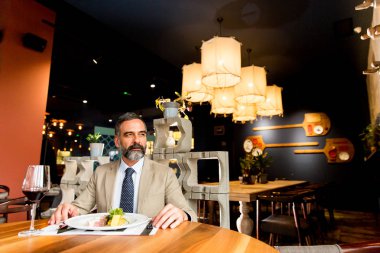 Öğle yemeği sırasında kırmızı şarap içme yakışıklı olgun adam