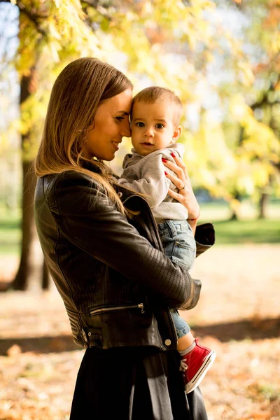 Ung mor och baby boy i höst park — Stockfoto