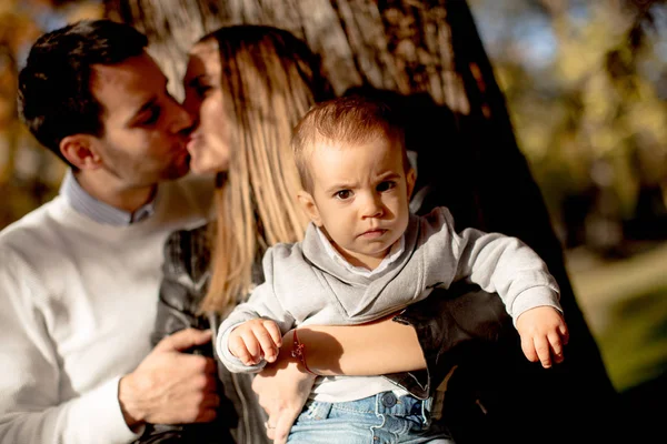 Jovens pais felizes com menino no parque de outono — Fotografia de Stock