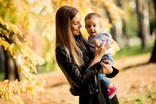 Joven madre y bebé en el parque de otoño — Foto de Stock