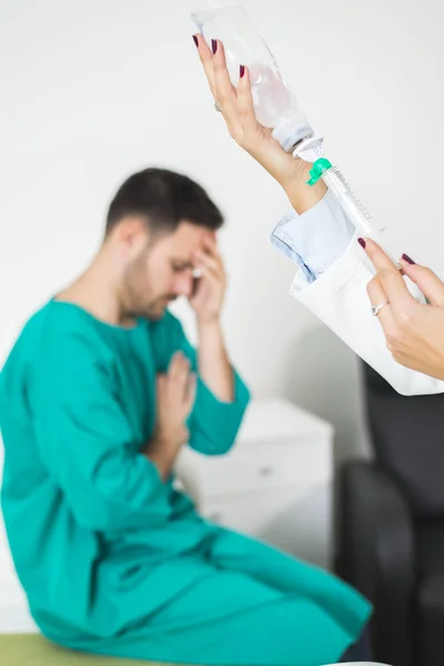 La doctora prepara una inyección mientras el paciente está en la cama. — Foto de Stock