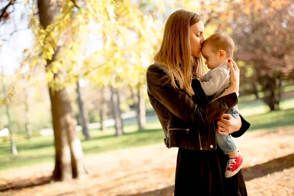 Giovane madre e bambino nel parco autunnale — Foto Stock