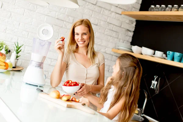 Mãe e filha na cozinha moderna preparando comida — Fotografia de Stock