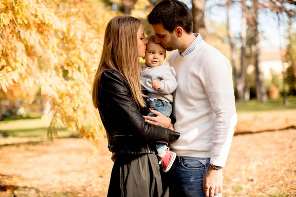 Happy young parents with baby boy in autumn park — Stock Photo, Image