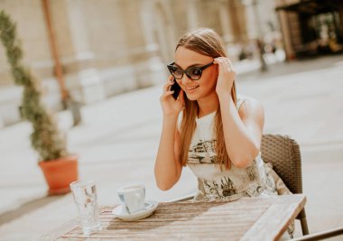 Cep telefonu kafede kullanan genç ve güzel kadın