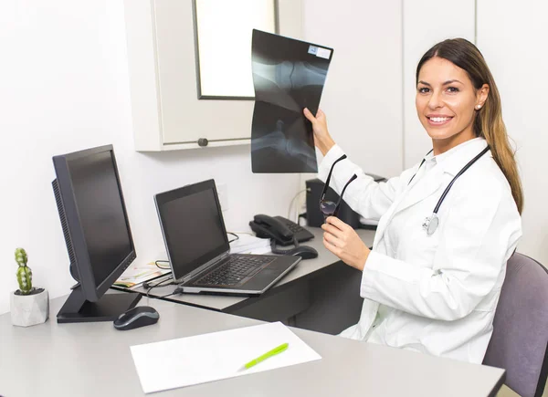 Kvinnliga läkare tittar på röntgenbilden av patienten i sjukhus — Stockfoto