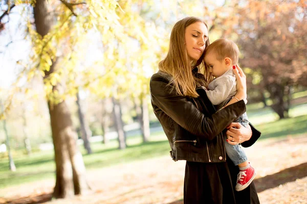 Junge Mutter und Junge im Herbstpark — Stockfoto