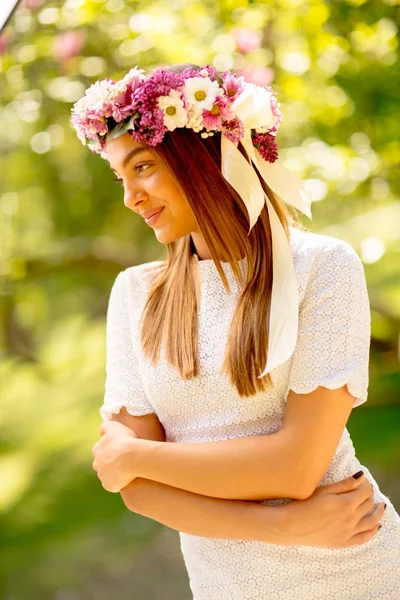 Portrait de jeune femme avec couronne de fleurs fraîches sur la tête — Photo