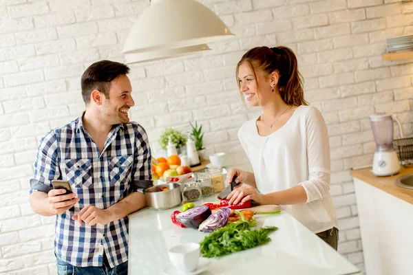 Pareja joven preparando comida saludable en la cocina — Foto de Stock