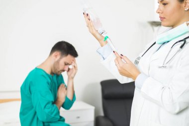 Hasta yatağında iken kadın doktor iğne hazırlar