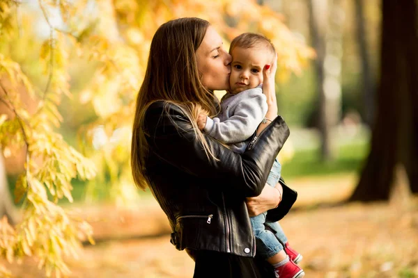 Jonge moeder en baby jongen in herfst park — Stockfoto