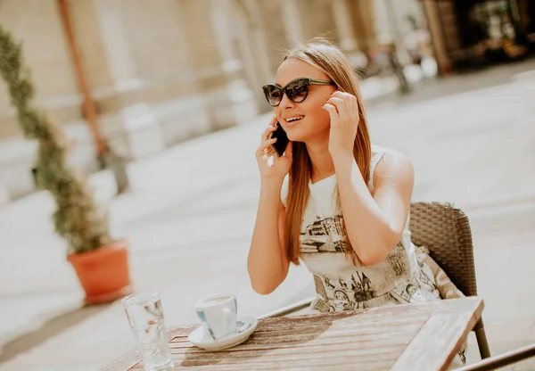 Mujer bastante joven usando el teléfono móvil en la cafetería — Foto de Stock