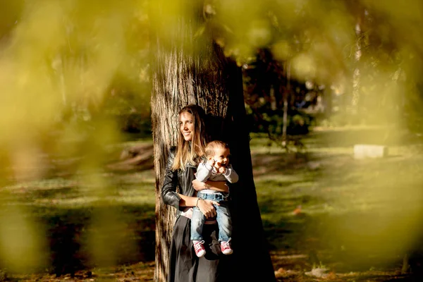 Ung mor och baby boy i höst park — Stockfoto