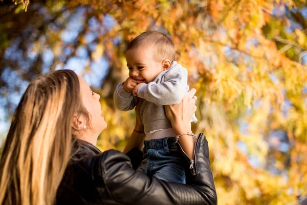 Jonge moeder en baby jongen in herfst park — Stockfoto