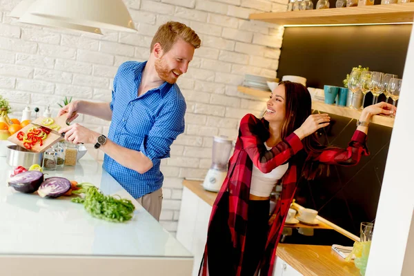 幸せな若いカップルがモダンなキッチン ランチの野菜料理の準備中に屋内で楽しい時を過す — ストック写真