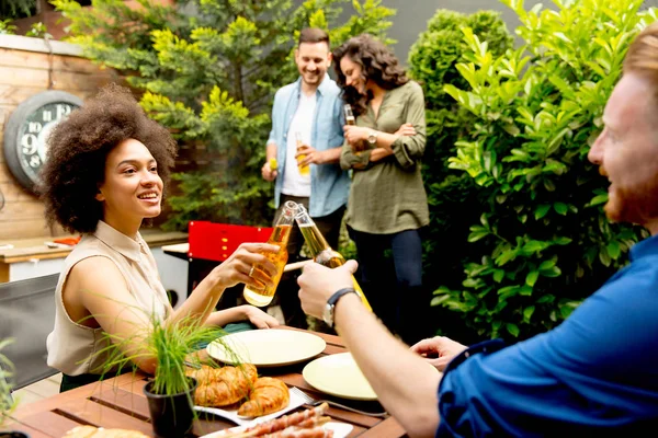 Amigos asando comida y disfrutando de la fiesta de barbacoa al aire libre — Foto de Stock