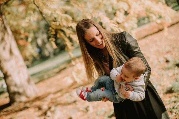 Mor och baby pojke att ha kul i höst park — Stockfoto