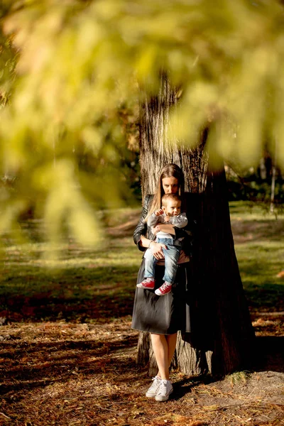 Ung mor och baby boy i höst park — Stockfoto