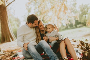 Sonbahar park yere oturan genç aile