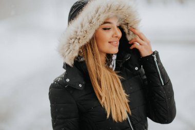 Hood bir karlı kış gününde olan genç ve güzel esmer kadın